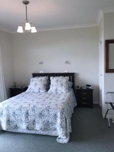 怀卡奈Apartment 45 @ Noble Estate的一间卧室配有一张带蓝色和白色棉被的床