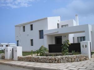 卡拉莫若尔Villa Elegante的前面有石墙的白色房子