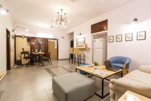班加罗尔Locul Uptown - Near Bangalore Palace Grounds的客厅配有沙发和桌子