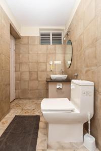 班加罗尔Locul Uptown - Near Bangalore Palace Grounds的浴室配有白色卫生间和盥洗盆。