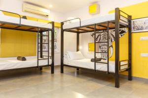 班加罗尔Locul Uptown - Near Bangalore Palace Grounds的黄色墙壁的客房内设有两张双层床。