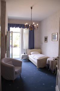 巴特皮尔蒙特阿尔特别墅施罗斯伯里克酒店的一间卧室配有一张大床和一个吊灯。