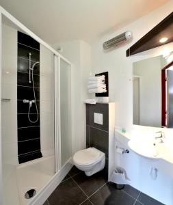 卡尔卡松The Originals City, Hôtel Pont Rouge (ex inter-hôtel), Carcassonne的浴室配有卫生间、盥洗盆和淋浴。