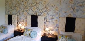 泰姆恩格兰兹玫瑰酒店的一间卧室设有两张床和鲜花墙