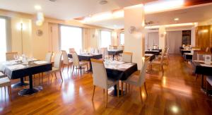 塞戈尔韦玛丽亚卢纳酒店的餐厅设有黑桌和白色椅子
