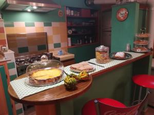 Strevi向日葵旅馆的厨房配有桌子和蛋糕