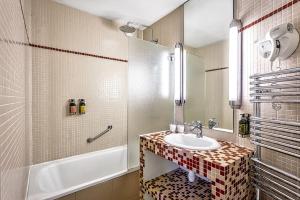 巴黎公园之星酒店的浴室配有盥洗盆和浴缸。