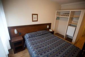 萨尔托Hotel Eldorado的一间卧室配有一张带蓝色棉被的床