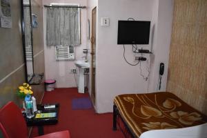 加尔各答Hotel Airways的一间小房间,设有带电视的客厅