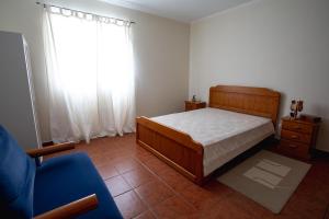 韦拉斯Casa dos Rui´s的卧室配有床、椅子和窗户。