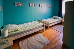 埃格尔Boros Vendégház Eger的配有蓝色墙壁和木地板的客房中的两张床
