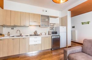 诺阿莱Novalesi Apartment的厨房配有木制橱柜和白色冰箱。