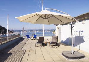 韦内雷港Terrazza Bello的屋顶上带椅子和遮阳伞的天井