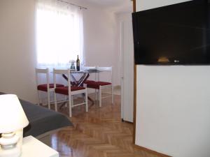 乌格连Apartment Vito的客厅设有餐桌和平面电视