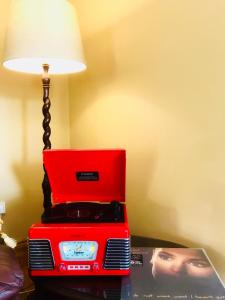 多尼戈尔The-Gables的一张红色的笔记本电脑坐在桌子上,上面有台灯