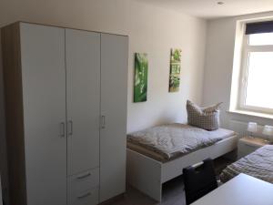 莱比锡Leipzig-in的一间卧室配有床和白色橱柜
