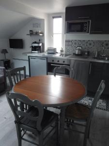 凡尔赛Les Tournelles的厨房配有木桌和桌椅