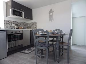 凡尔赛Les Tournelles的厨房配有桌椅和微波炉。