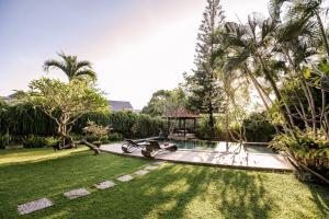 坎古Villa Puri Burung的庭院内带游泳池的花园