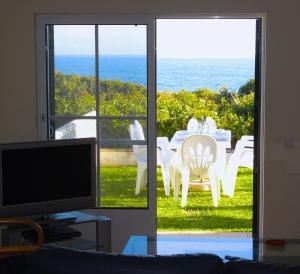 贝纳吉Casa Rosa Azul - Terracos de Benagil (Cliffside)的带电视的客厅,享有海景。