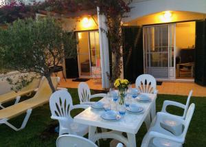 贝纳吉Casa Rosa Azul - Terracos de Benagil (Cliffside)的院子里的白色桌子和椅子