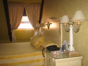 贝纳文特圣地亚哥酒店的一间卧室配有一张带台灯的床铺,