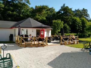 TingstädeGotland of Sweden - bed & breakfast的公园里带桌子和遮阳伞的餐厅
