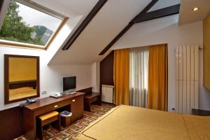 锡纳亚Casa Iris-Hotel & Restaurant的一间卧室设有一张床、一台电视和一个窗口。
