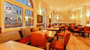 松德斯豪森图灵根酒店的配有木桌和橙色椅子的餐厅
