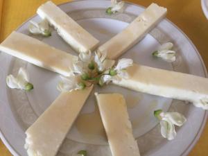 曼恰诺Poggio Moretto的一块盘子,上面有三块奶酪和鲜花