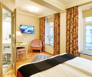 哥德堡皇家酒店的酒店客房设有一张床、一张书桌和窗户。