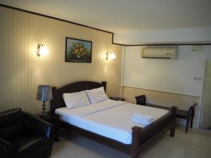 北榄坡纳克萨瓦酒店的配有一张床和一把椅子的酒店客房