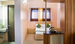 浦那Treebo Trend Naunidh Suites的酒店客房配有一张床、一张桌子和咖啡壶
