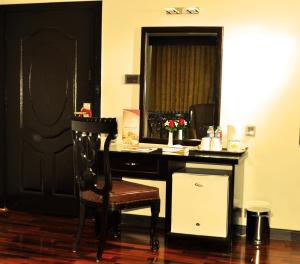 卡拉尔哥特Hotel One Sukkur的客房设有带椅子和镜子的书桌