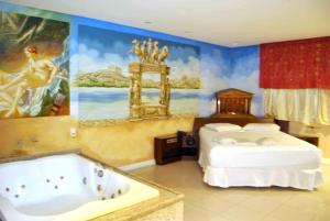 萨尔瓦多Motel KamaSutra的一间卧室配有一张床和浴缸