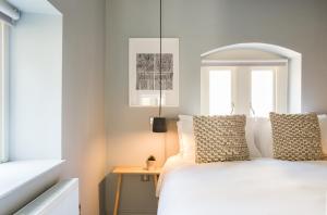 巴斯Hiding Space - St Catherine's Hospital Apartments的卧室配有白色的床和窗户。