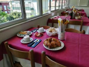 博尔焦韦雷齐Albergo Calcagno的一张桌子,上面有紫色的桌布,上面有面包和糕点
