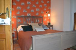 LicquesLa Longère d'Ecottes的一间卧室配有一张橙色墙壁的床