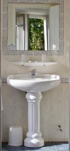 卢尔德Hôtel Sainte Marie的浴室设有白色水槽和镜子