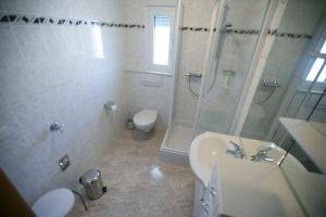 克拉默特Susanna Apartments的带淋浴、盥洗盆和卫生间的浴室