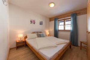 菲伯布伦Bio-Bauernhof Niederlehen的一间卧室配有一张带白色床单的床和一扇窗户。