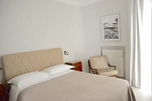 阿尔塔穆拉Vacanze Murgiane的卧室配有白色的床和椅子