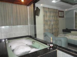 Nilópolis普雷米尔酒店（仅限成人）的带浴缸和一瓶葡萄酒的浴室