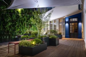 巴黎摄政王Spa公寓式酒店的建筑前方种有盆栽植物的庭院