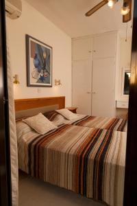 阿依纳帕Annita Court Bock B, Apt3的一间卧室配有一张带条纹毯子的大床