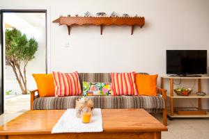 阿依纳帕Annita Court Bock B, Apt3的客厅配有带橙色枕头的沙发