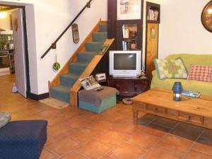 KnockThe Lake House, Connemara的带沙发和电视的客厅以及楼梯。