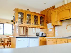 米尔敦马尔贝Flynn's Cottage的厨房配有木制橱柜和台面