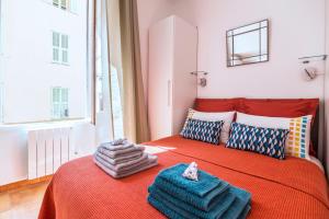 尼斯奥利维特公寓的一间卧室配有红色的床和毛巾