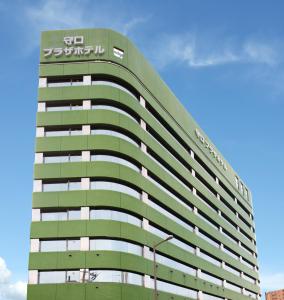 大阪大阪守口广场酒店 的一座高大的绿色建筑,上面有标志